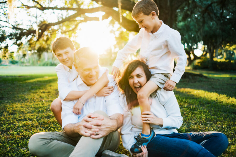a family plays together during their family portrait session at Hampton Park in downtown Charleston, SC