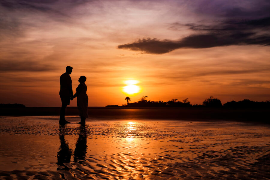 Sunset silhouette of couple on Folly Beach: Chrisman Studios