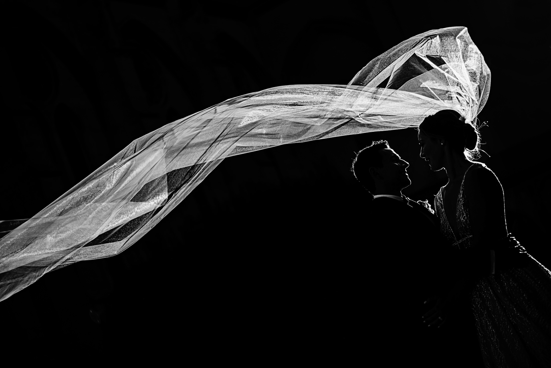 A bride and groom sunlit silhouette portrait outside Grace Cathedral in San Francisco.