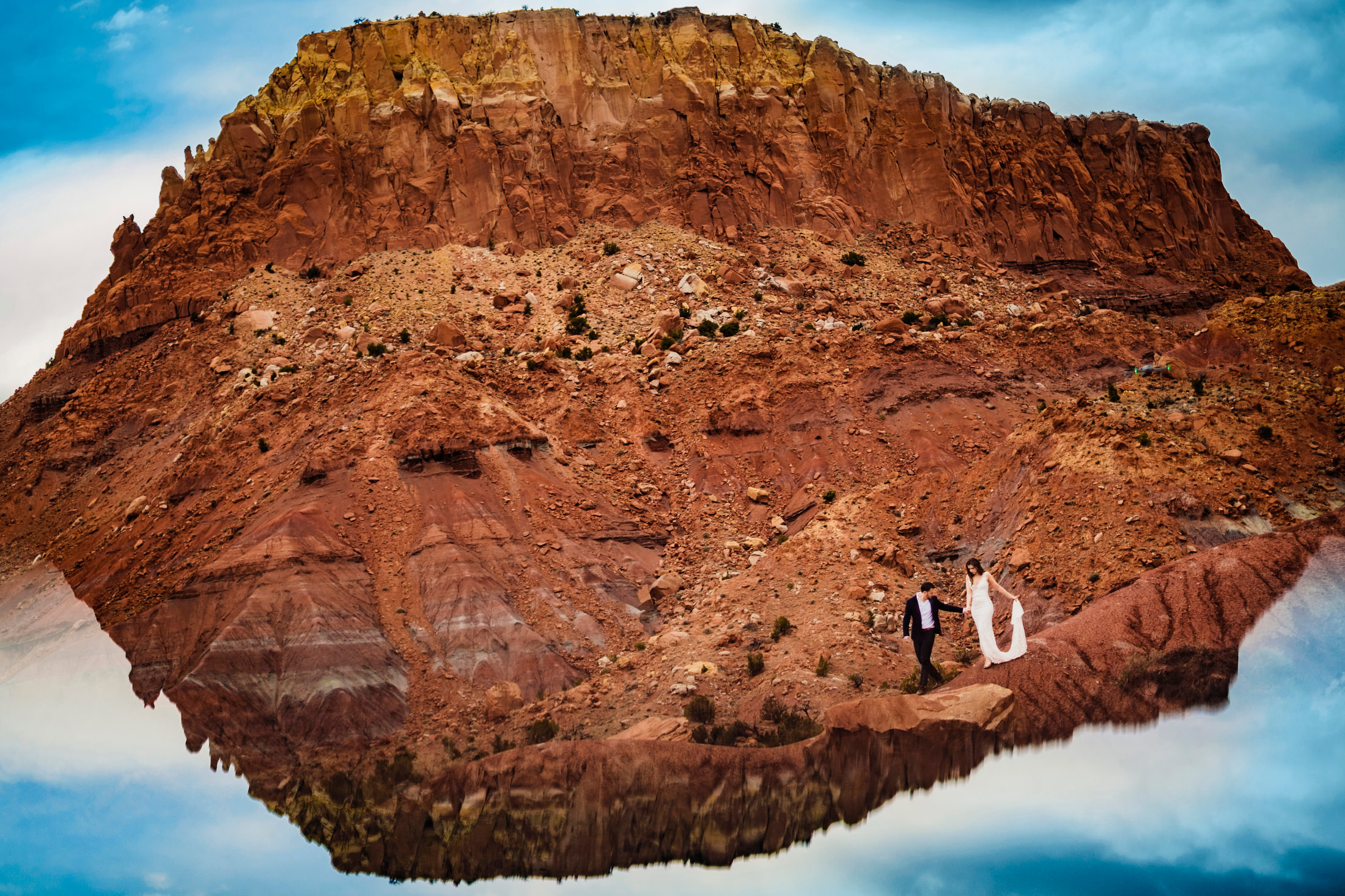 Bride and groom climb mountain outside Santa Fe New Mexico.