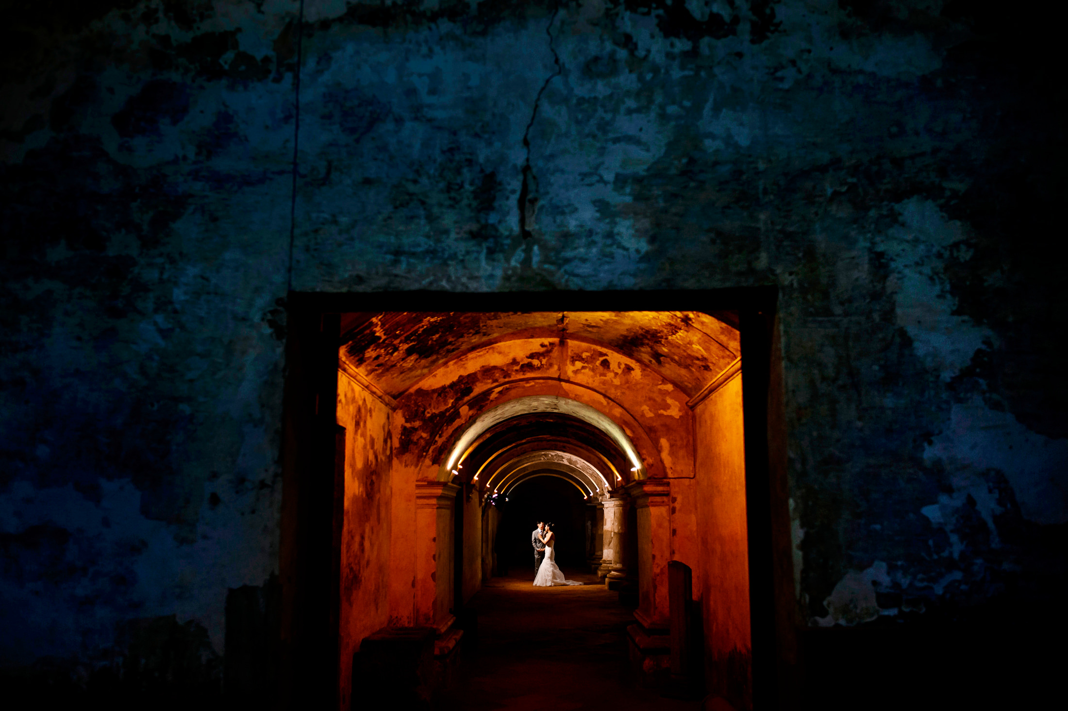 A bride and groom embrace in old building during their destination wedding in Antigua.