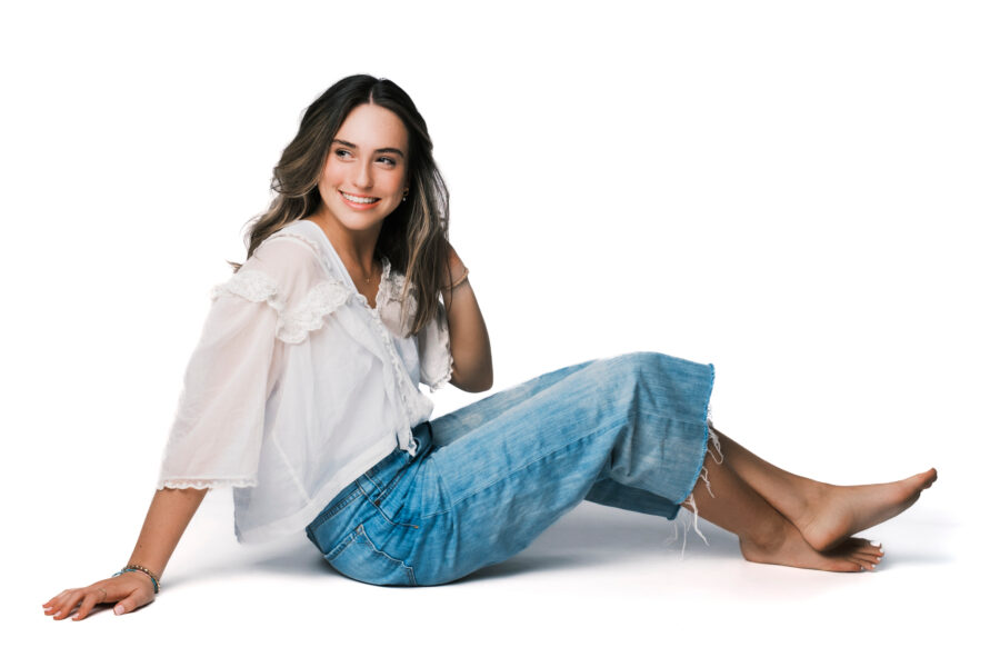 woman smiling sitting casual outfit white background
